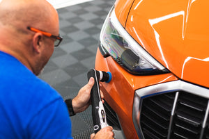 A person using a rupes da coarse pad on a polisher.