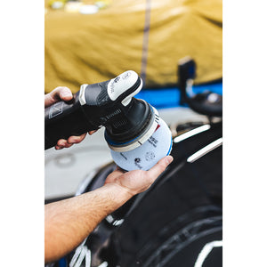 A person putting a blue polish pad onto a Rupes polisher.