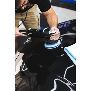 A person polishing the hood of a black car.