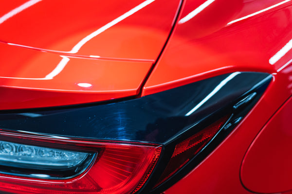 Close-up of a red car's front head light