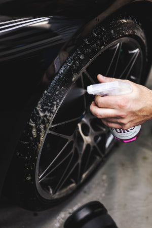 A hand spraying a car tire with Stjarnagloss Forst.