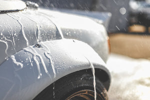 Water running down the side of a white car.