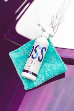 A spray bottle of Stjarnagloss Slike on a blue microfiber towel.