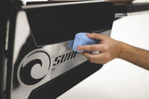 A person cleaning a sign with a blue terry sponge.