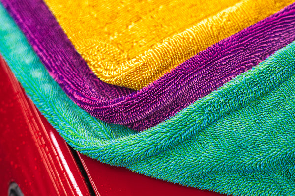 The Liquid8r Colorburst all color options folded onto the hood of a red car close up view.