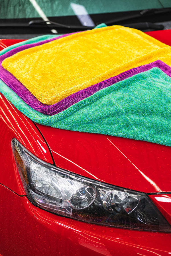 The Liquid8r Colorburst all color options folded onto the hood of a red car.