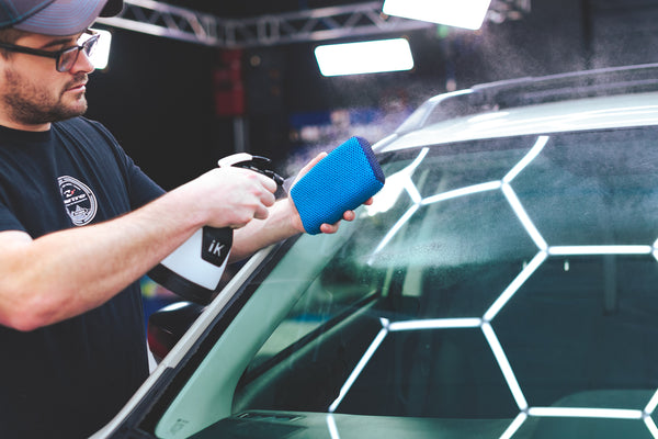 A person spraying the Ultra Clay Scrubber with a spray bottle.