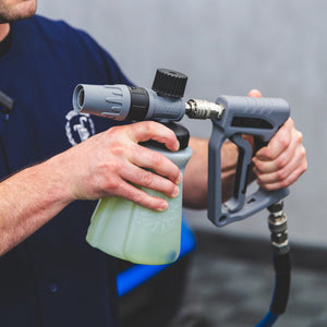 A person connecting a TRC Ultra H2O Foam Cannon to the TRC Ultra H2O Spray Gun.