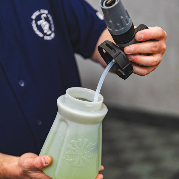 A person holding the top of a TRC Ultra H2O Foam Cannon to show the weighted tube.