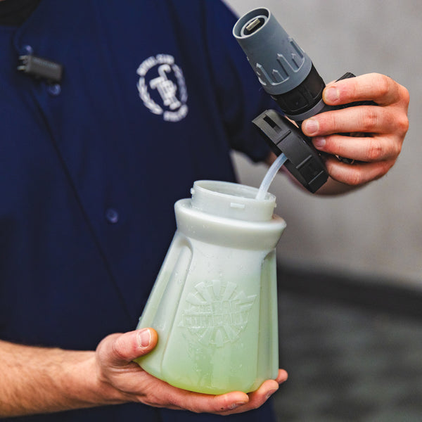 A person holding the top of a TRC Ultra H2O Foam Cannon to show the weighted tube.