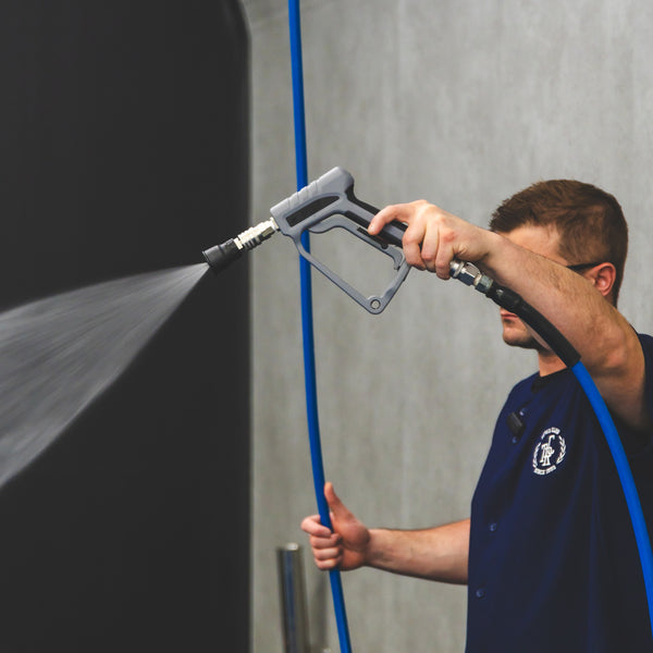 A person spraying water using a TRC Ultra H2O Spray Gun.