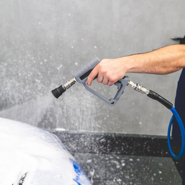 A close up of a TRC Ultra H2O Spray Nozzle on a TRC Ultra H2O Spray Gun cleaning a blue car.