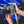 A close up of a TRC Ultra H2O Spray Nozzle being placed into the holder on a TRC Ultra H2O Spray Gun with a blurry blue car in the background.