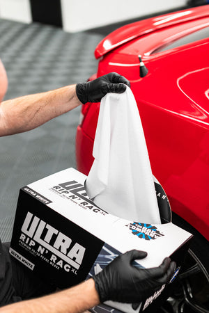 TRC Ultra Rip N' Rag Ultra white being pulled out of the packaging to be used on a red Scion. 