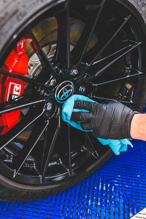 A hand cleaning a tire rim with the Ultra Rip N' Rag XL.