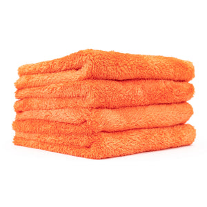 A stack of four orange Eagle Edgeless 500 towels on a white background.