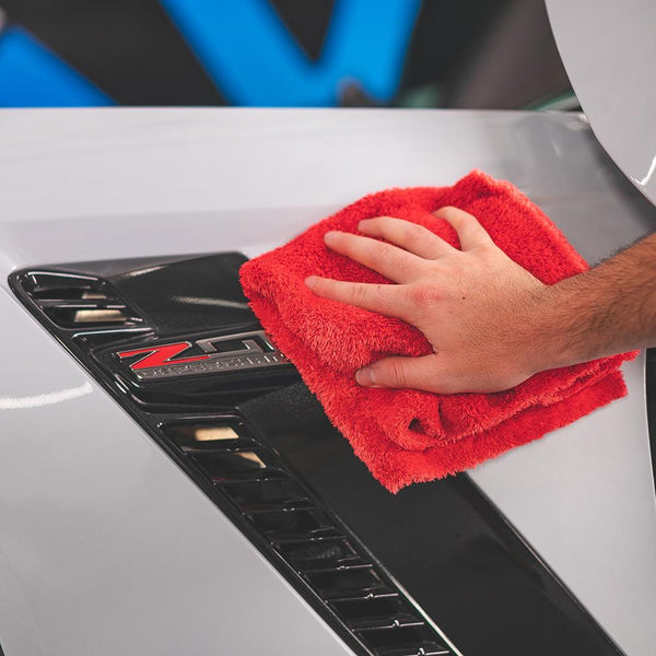 Using a red Eagle Edgeless 500 microfiber towel from The Rag Company to clean the exterior of a supercharged Z06 Chevrolet Corvette