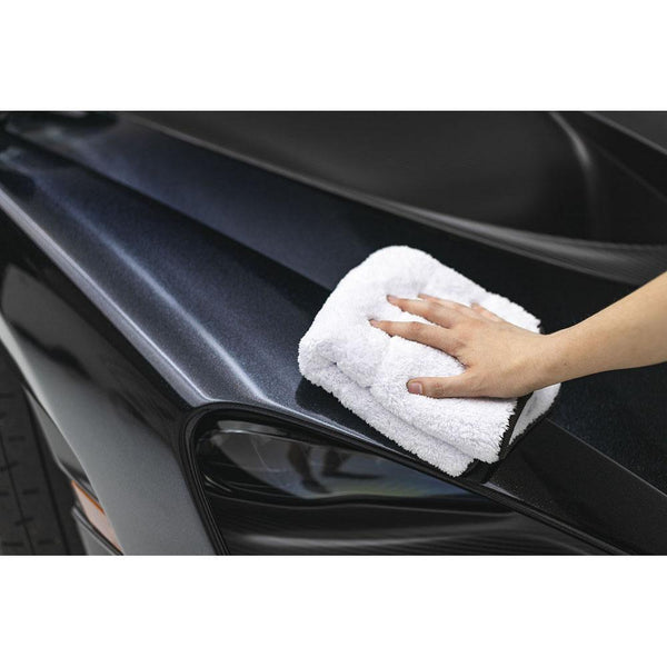 White microfiber towel being used to clean a black car