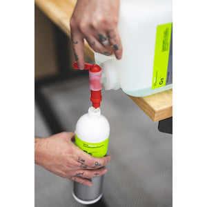 A closeup of a person using the Koch Chemie Tap on a jug of Koch Chemie Green Star to pour into a bottle of Green Star.