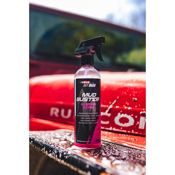 A spray bottle of P&S Mud Buster on the hood of a freshly cleaned red jeep.