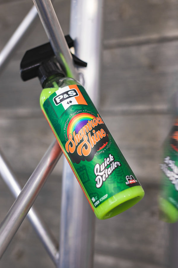 A spray bottle of Shamrock Shine hanging from a metal trust by the handle.