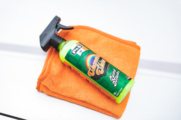 A spray bottle of Shamrock Shine on an orange towel on a white background.