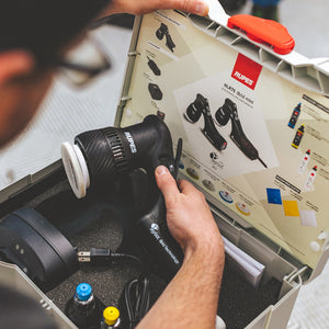 A closeup of a person opening up a Rupes polisher case.