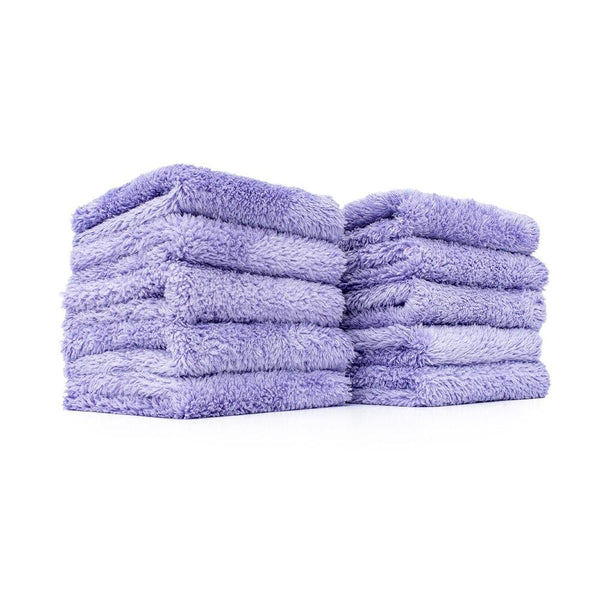 Two stacks of five purple towels on a white background