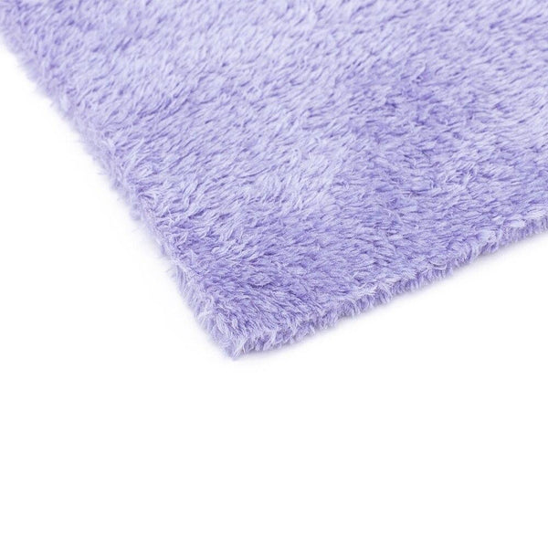 Corner of a purple microfiber towel on a white background